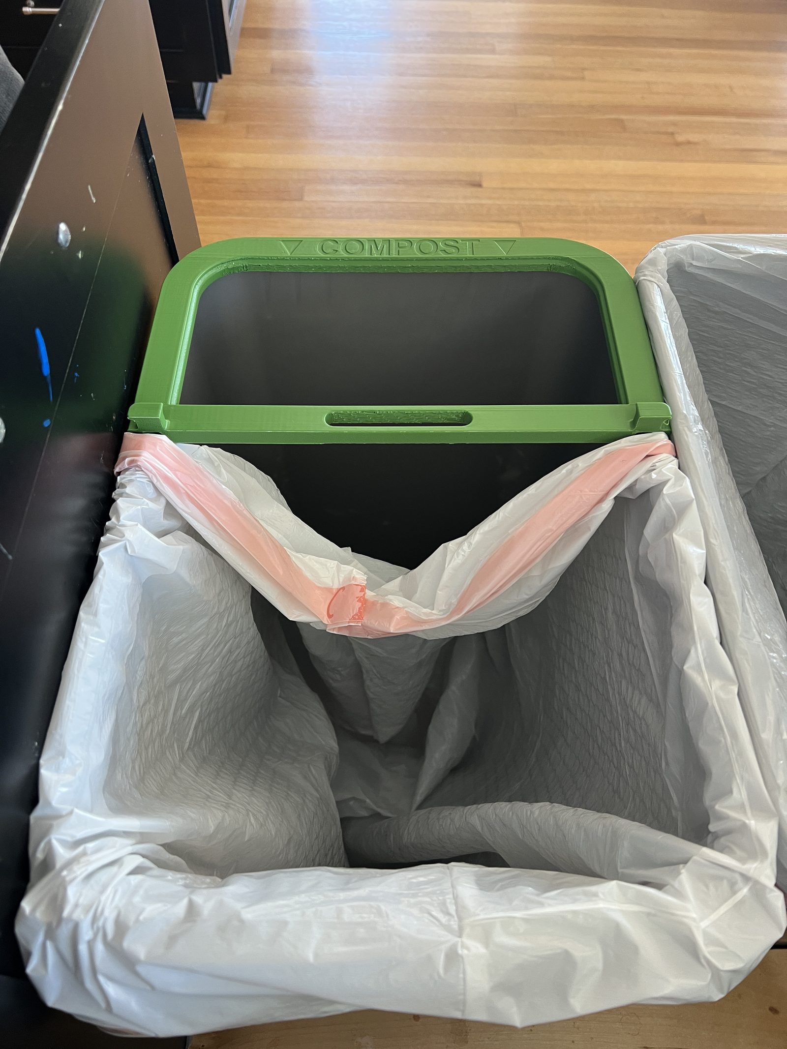 Green COMPOST rim placed on top of the pull-out trash can