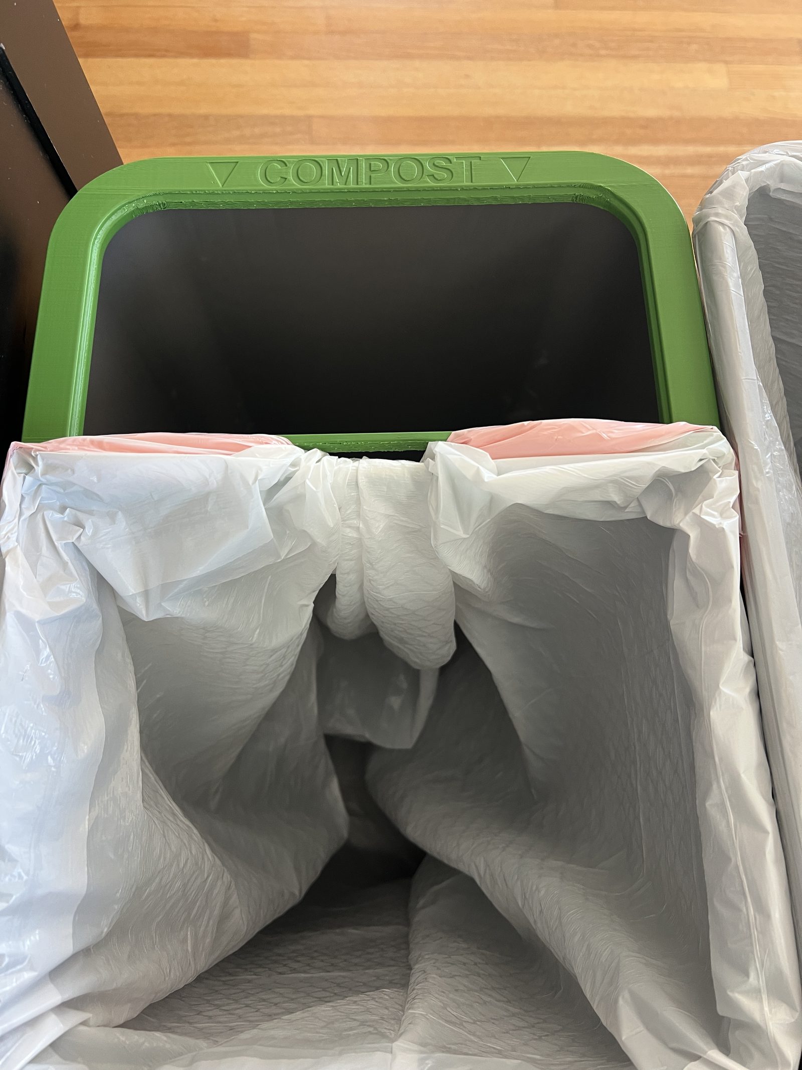 Trash bag pulled to the side and connected to the edge of the CompostFit rim